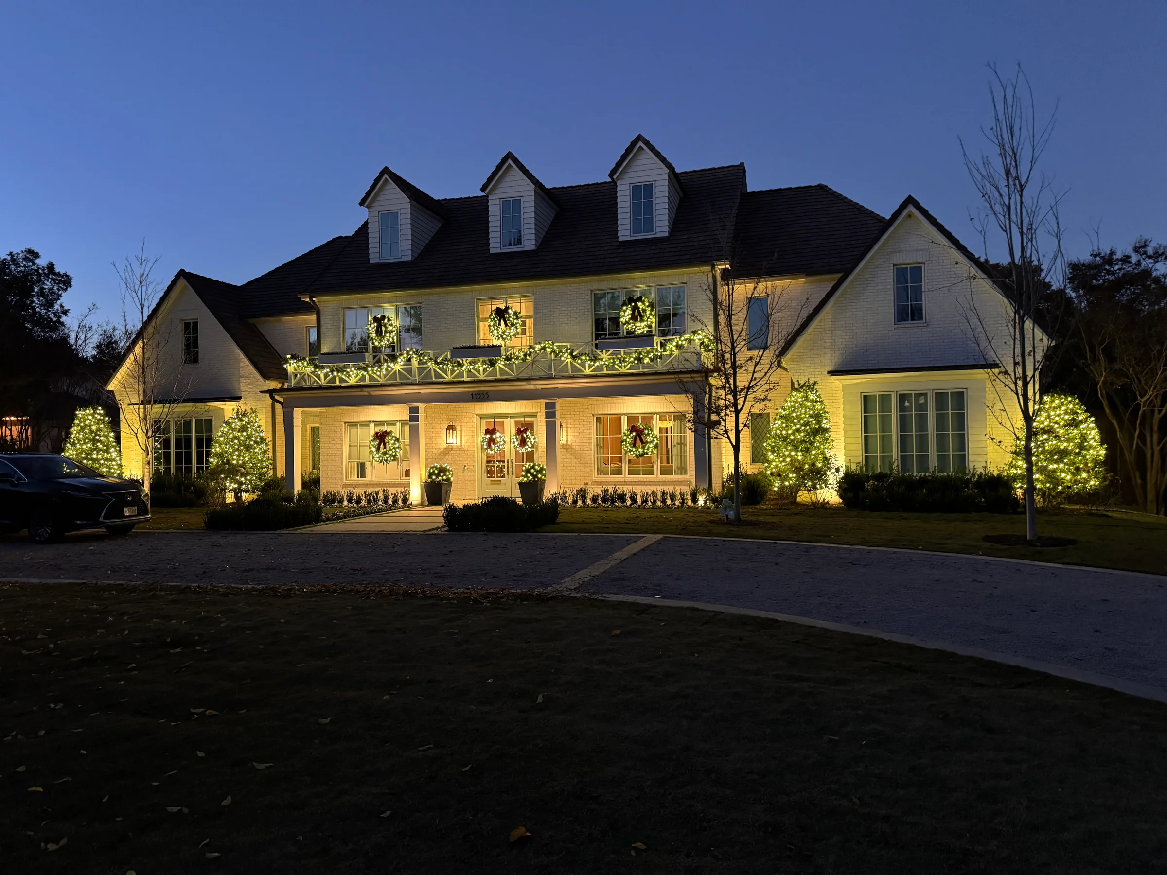 White-brick home with warm Christmas and tree lighting
