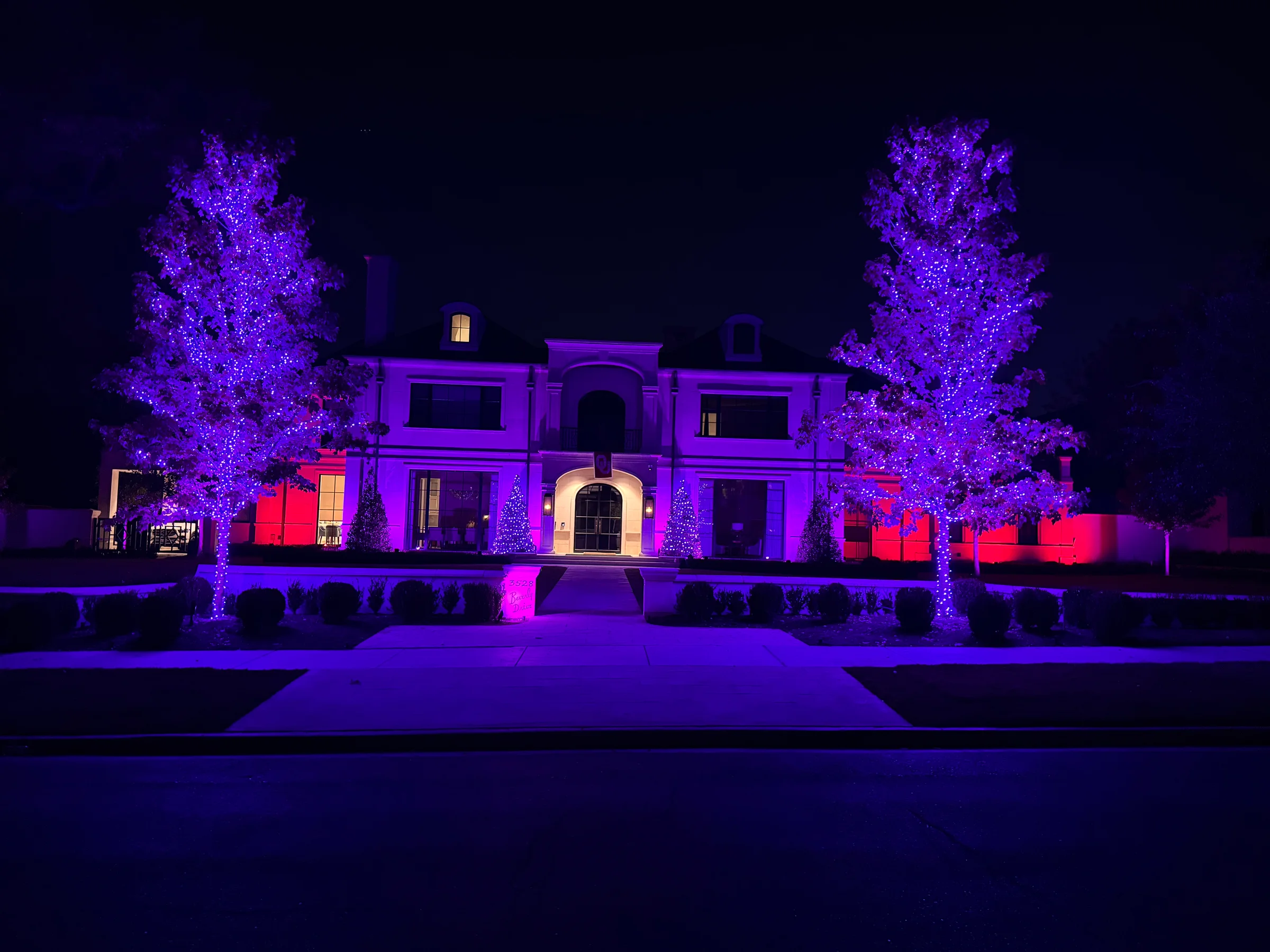 Modern home facade illuminated with purple and warm white accent lighting