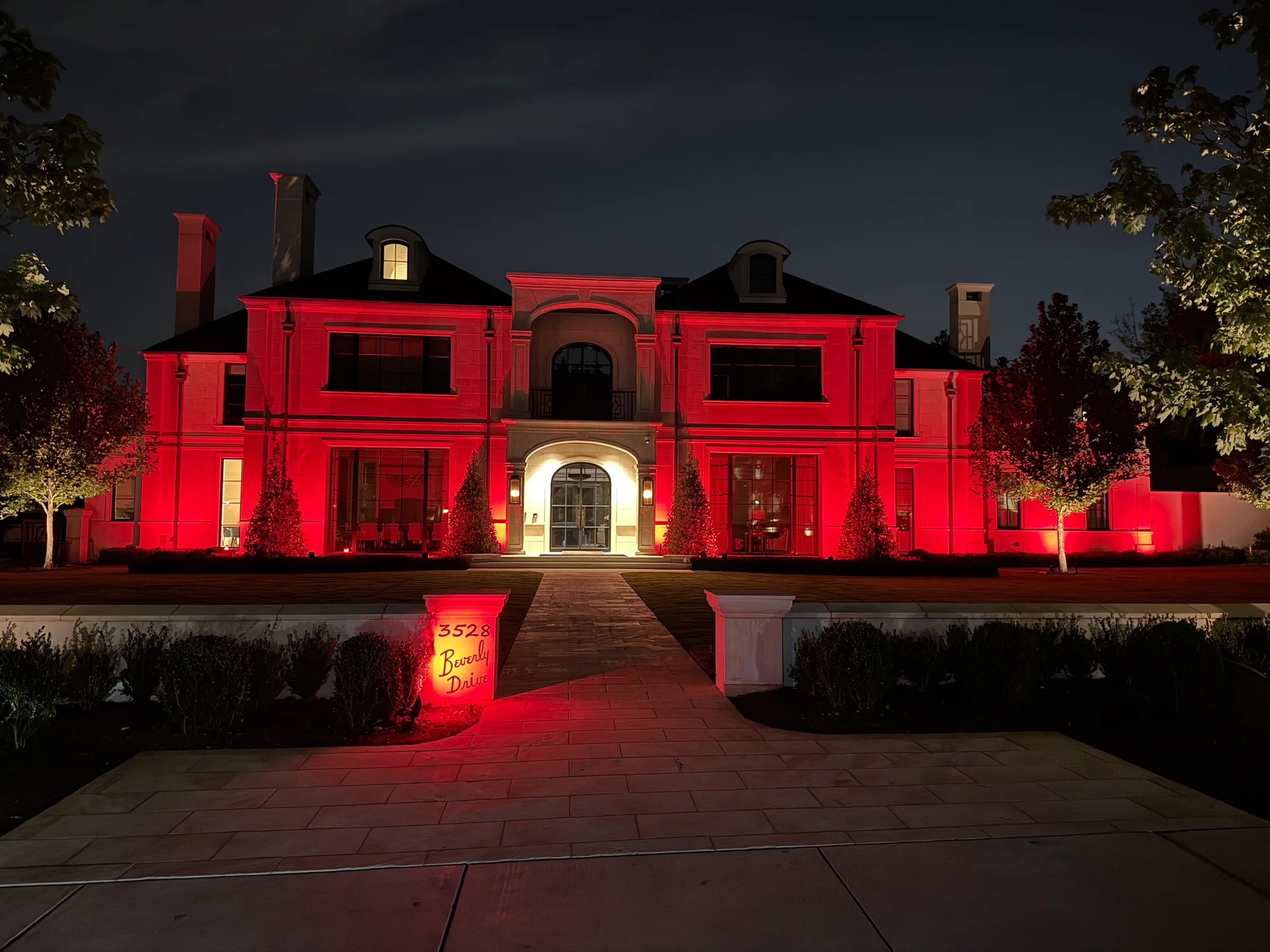 Estate facade washed in red architectural light