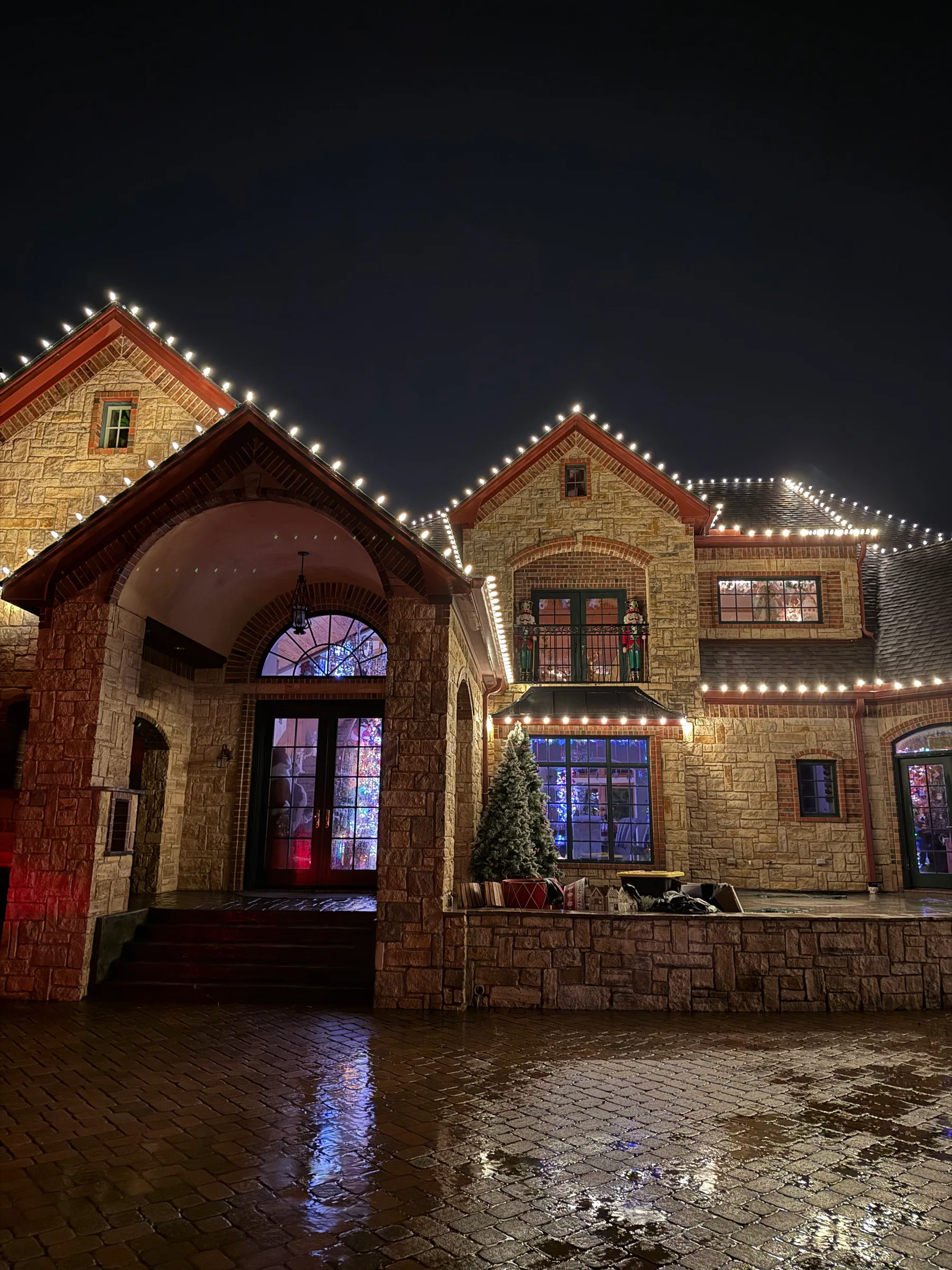Home facade and roofline illuminated with warm white lights